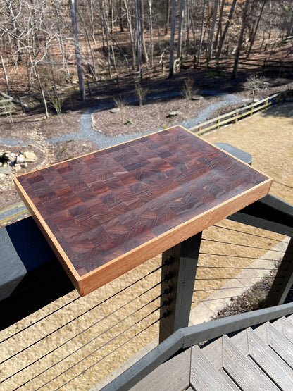 Three-quarter view of a handcrafted end grain cutting board showing thickness and contrasting hardwood border