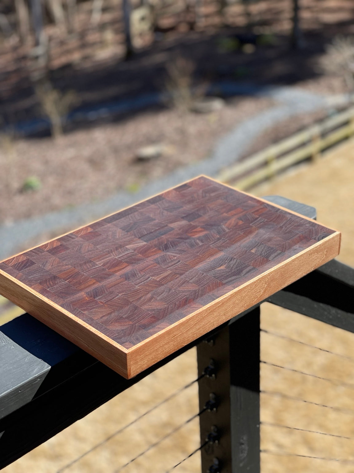 Handcrafted end grain cutting board with dark hardwood blocks and contrasting border