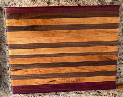 Overhead view of handcrafted mixed hardwood side grain cutting board with Purpleheart accents