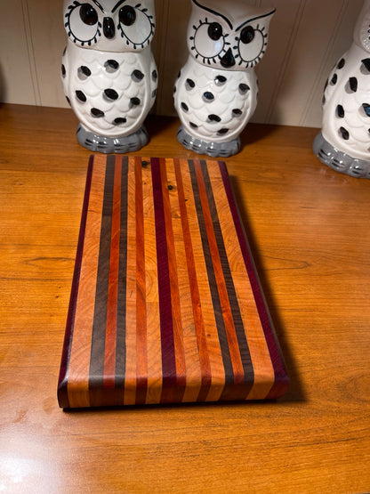 Custom mixed-hardwood side grain cutting board with contrasting strips and Purpleheart accents